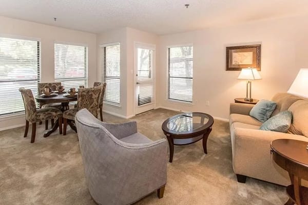 A bright and inviting living room with a dining area and large windows.