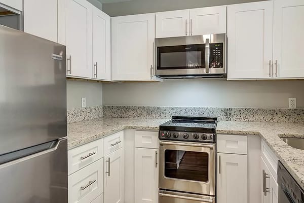 A modern kitchen with stainless steel appliances and granite countertops.