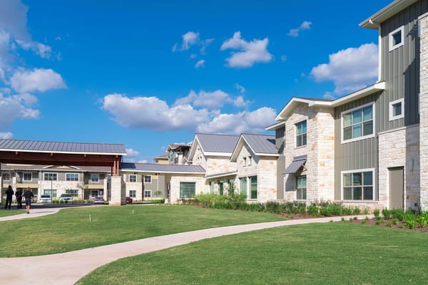Exterior of The Delaney at Georgetown Village featuring landscaped grounds and buildings.