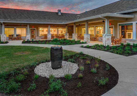 A landscaped outdoor patio with a stone fountain at The Delaney at Georgetown Village