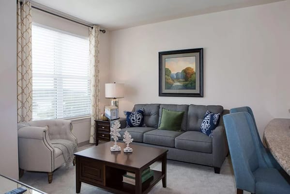 Comfortable living room featuring a sofa and armchair with natural light.