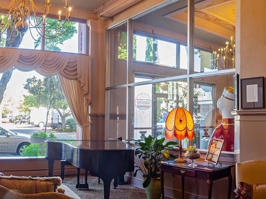 Bright interior common area with piano and window view
