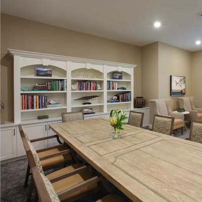 Spacious community room with bookshelves and a large wooden table
