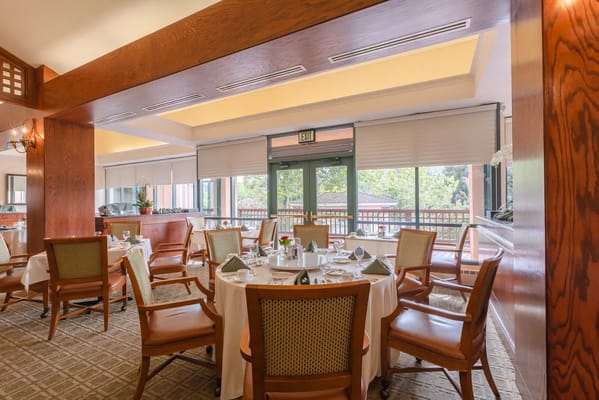 Dining room setup with tables and chairs in a bright interior