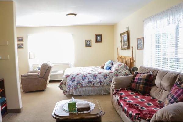 Cozy resident room with floral bedding and seating area