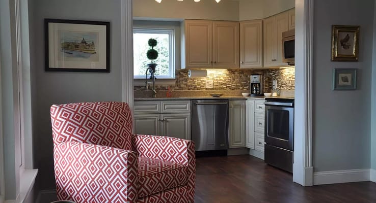 Bright kitchen with modern appliances and a red patterned chair