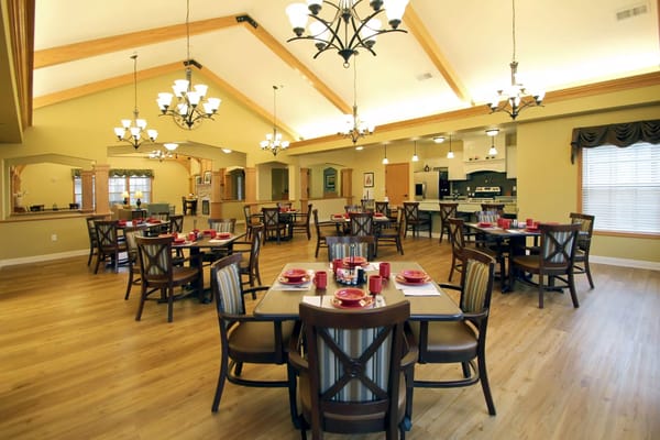 Spacious dining room with wooden tables set for meals