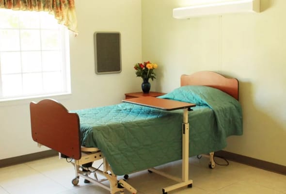 A private resident room with a bed and flowers