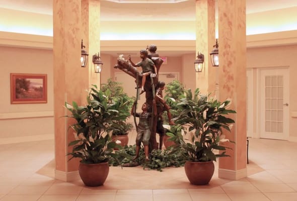 Interior lobby with a children's sculpture and plants