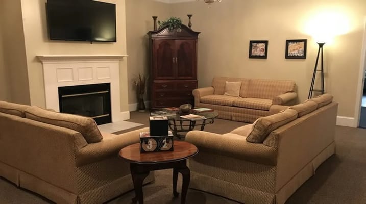A cozy living room with sofas, a coffee table, and a fireplace.