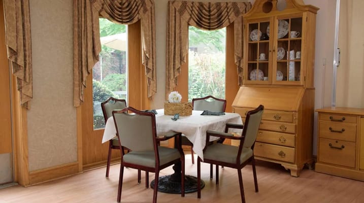 Cozy dining table set in a well-lit room with large windows.
