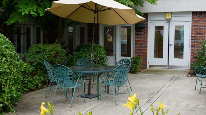 Outdoor seating area with a table and chairs under an umbrella