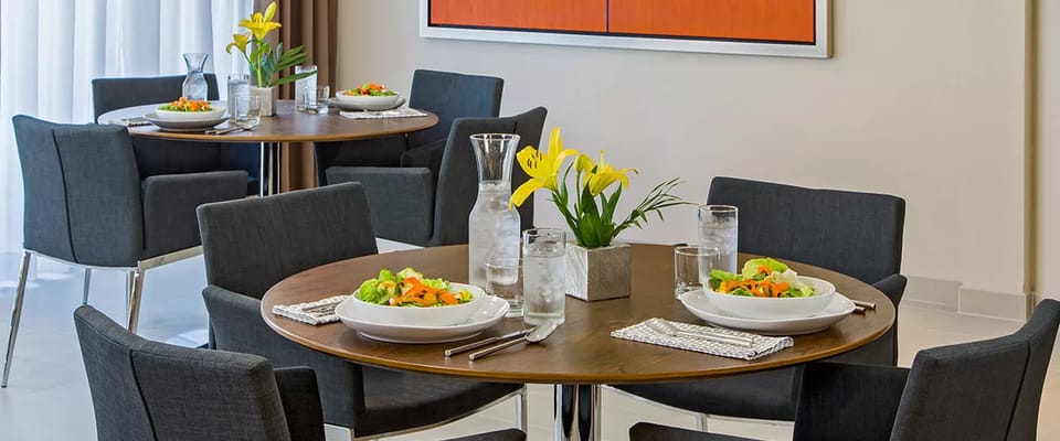 Modern dining setup with salads and flowers on the table