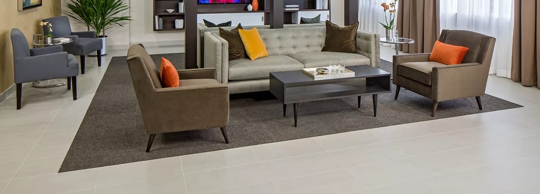 Stylish living room with a gray couch and orange accents.