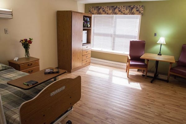 A cozy resident room with a bed and seating area