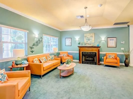 A bright common area with orange seating and green walls