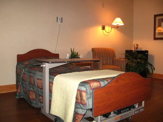 A private resident room with a bed and chair