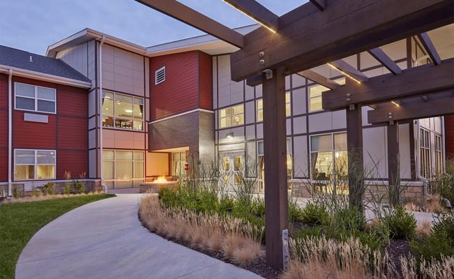 Pathway leading to the entrance of The Healthcare Resort of Kansas City, surrounded by landscaping.