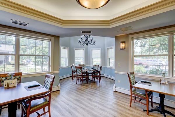 Bright dining area with tables and chairs near large windows.