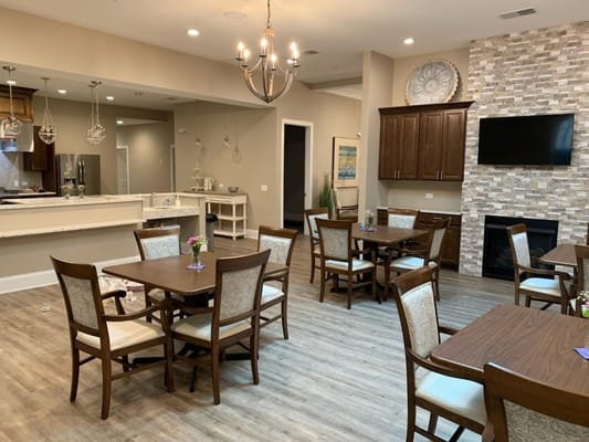 Spacious dining area with wooden tables and chairs in a senior living facility