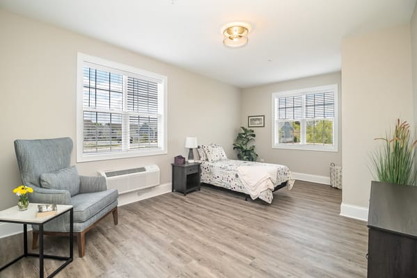 Bright and airy senior living room with a bed and seating area