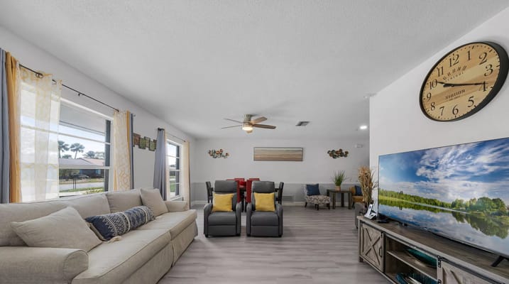 Bright and inviting living room with comfortable seating and a TV.