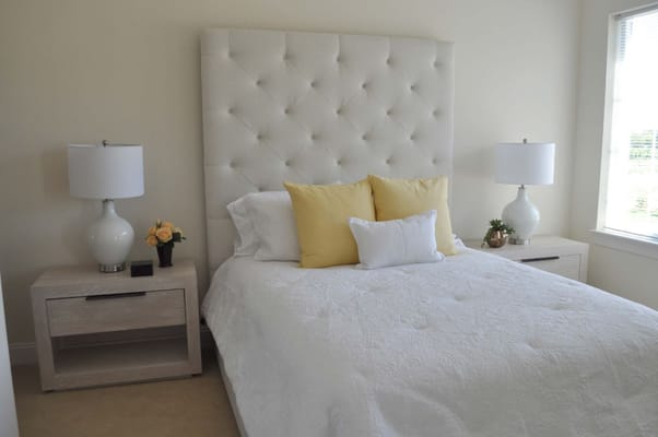 A well-decorated bedroom with a white bedspread and colorful pillows.