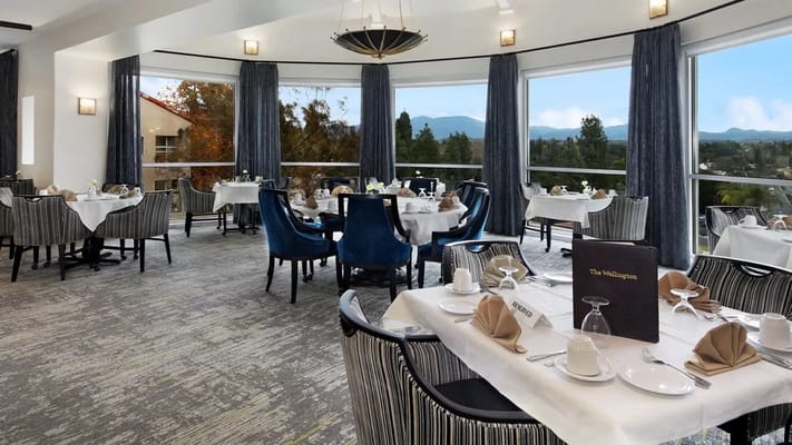 Elegant dining area with tables set for meals and large windows