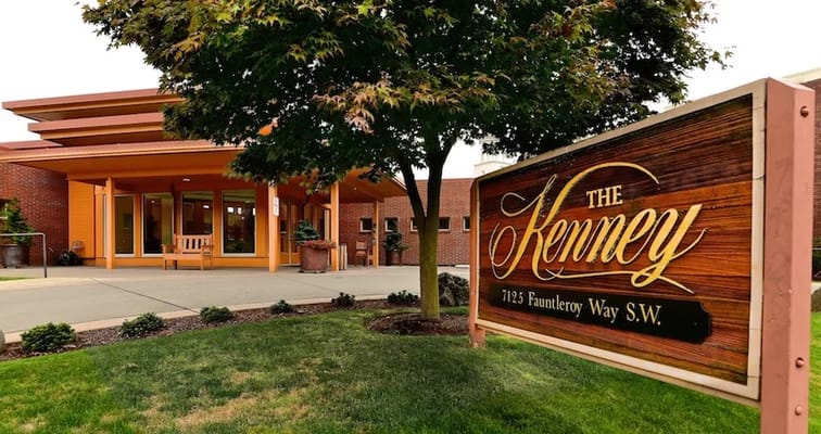 The entrance of The Kenney with a wooden sign displaying the name.