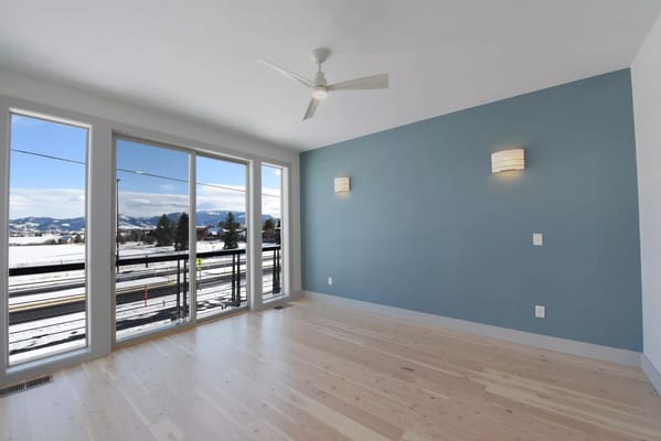 Spacious living room with large windows and a view of mountains.