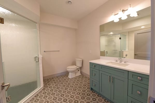 Spacious bathroom with a glass shower and blue vanity
