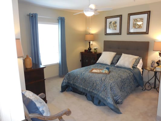 A cozy bedroom with a bed, lamps, and decorative items