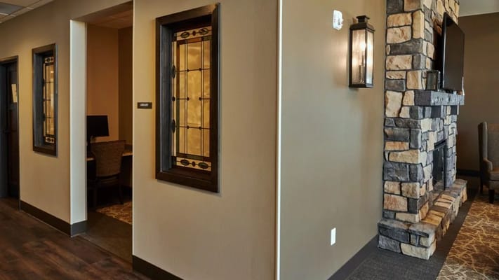 Cozy library area with stained glass windows and a stone fireplace