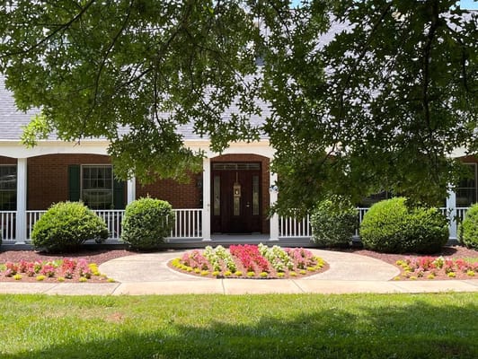 Welcoming entrance with flower beds and porch