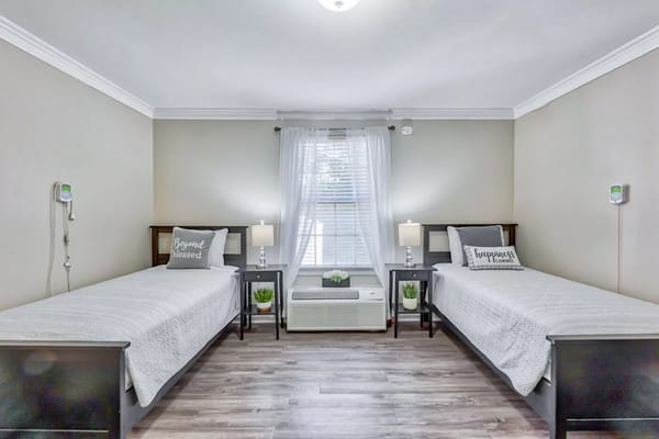 Bright, welcoming twin bedroom setup for residents
