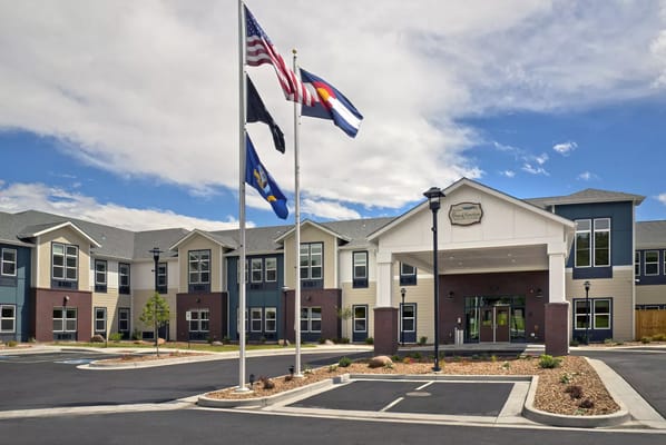 Exterior of The Lodge at Grand Junction with flags and parking area