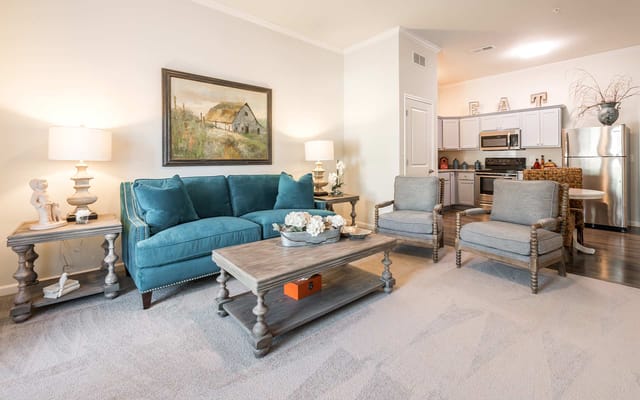 Bright living room with teal sofa and modern kitchen