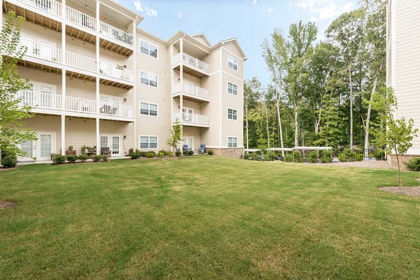 View of the exterior of The Mansions at Sandy Springs with balconies and green lawn