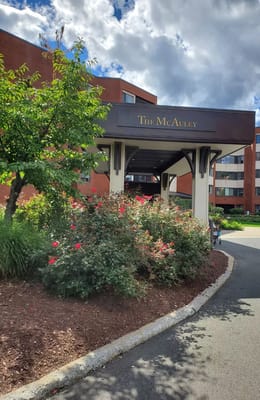 Exterior view of The McAuley with flowers and signage