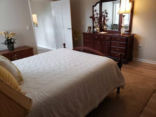 Cozy resident room featuring a bed and dresser