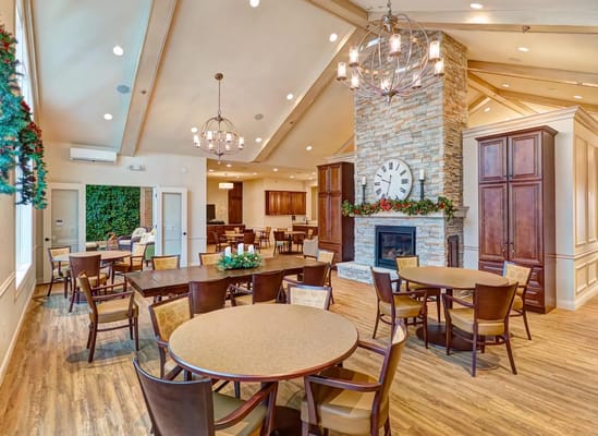 Spacious dining area with round tables and a stone fireplace