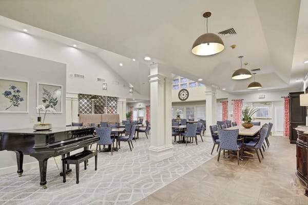 Spacious common area with piano and dining tables