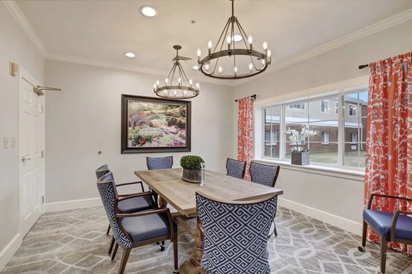 Meeting room with a wooden table, blue chairs, and decorative lights