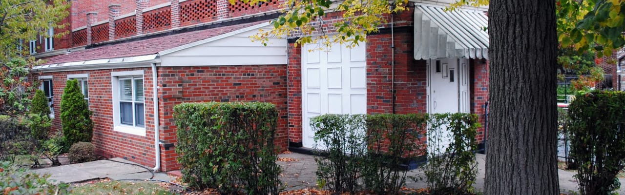 Brick exterior of The New Homestead Home with landscaping