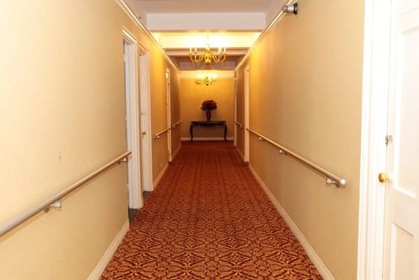 A corridor with handrails and decorative lighting at The New Homestead Home