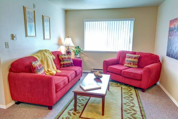 Bright living room with red couches and a coffee table