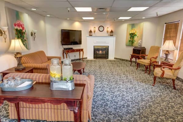 Cozy living room with seating, a fireplace, and refreshments