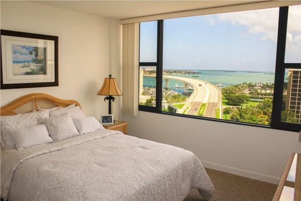 A bright bedroom with a view overlooking a bay