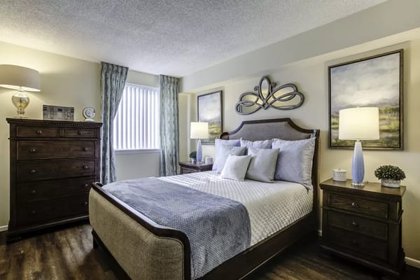 Stylish bedroom with a bed, dresser, and bedside tables.