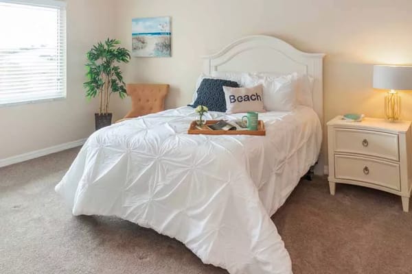 Bright and inviting bedroom with a bed, nightstand, and decor.